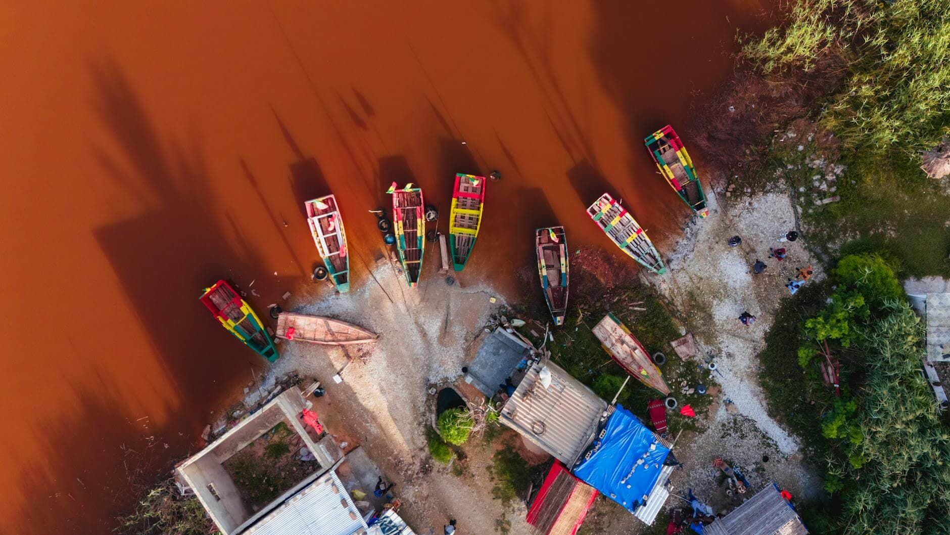 Playa de arena dorada en Saly, Petite Côte, Senegal, con piraguas de colores y palmeras