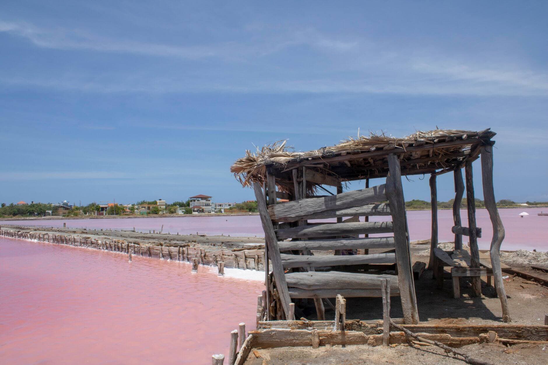 Vista aérea del Lago Retba con sus aguas de color rosa intenso y extractores de sal en Senegal