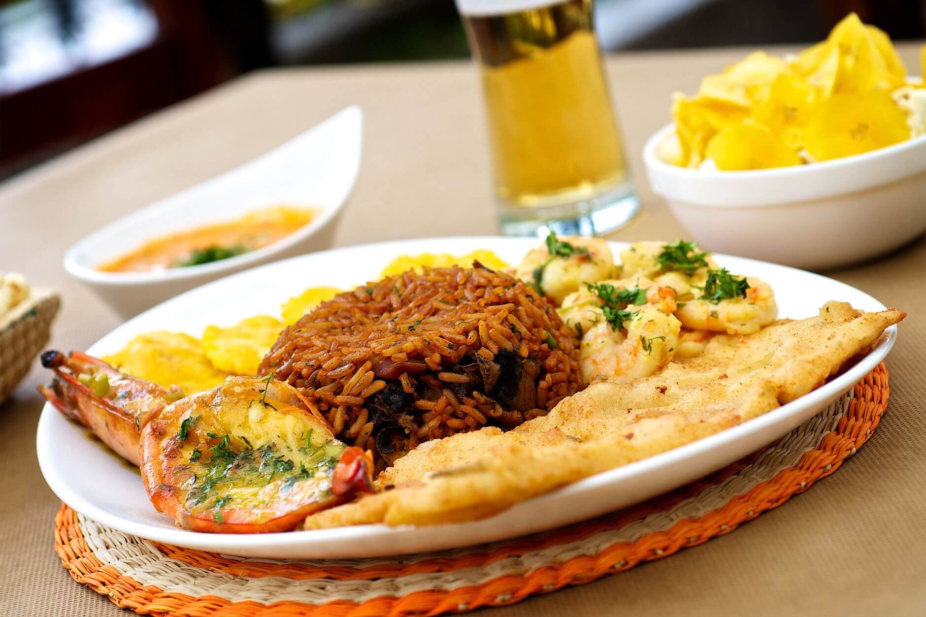 Plato tradicional de thiéboudienne senegalés con arroz, pescado y verduras en bandeja compartida